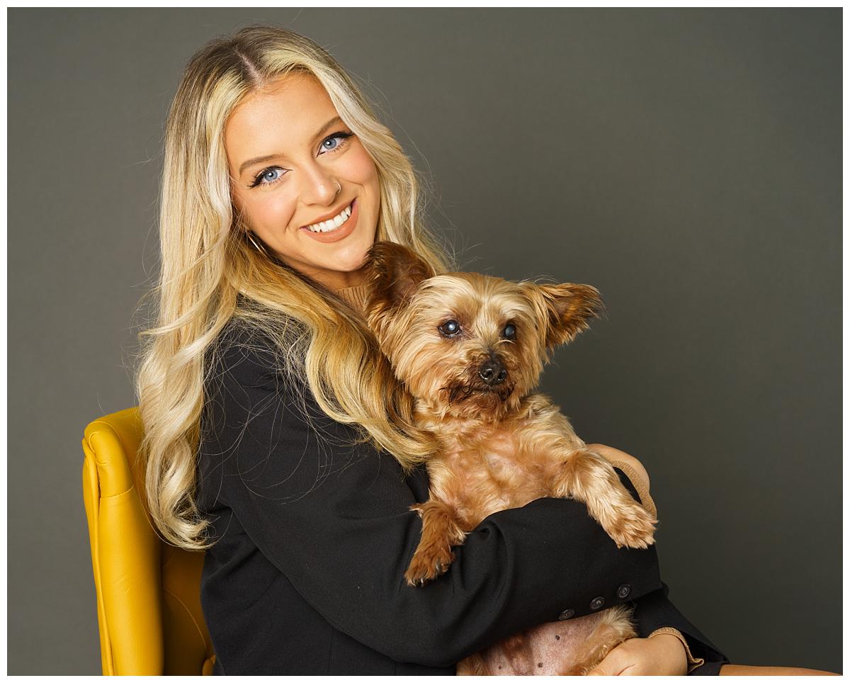 Professional pet photograph, taken by Northern Ireland's top pet photographer in Belfast of small dog with a girl on a yellow chair